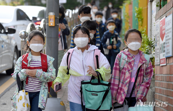 [광주=뉴시스] 류형근 기자 = 실외에서 마스크를 착용하지 않아도 되는 2일 오전 광주 남구 한 초등학교에서 학생들이 마스크를 착용한 채 등교하고 있다. 2022.05.02. hgryu77@newsis.com