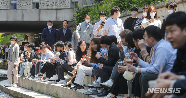 [서울=뉴시스] 권창회 기자 = 실외 마스크 의무화 해제 첫 날인 2일 오후 서울 중구 청계천에서 직장인들이 점심시간을 맞아 마스크를 벗고 휴식을 취하고 있다. 2022.05.02. kch0523@newsis.com