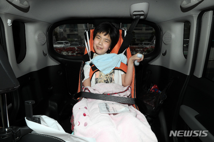[대구=뉴시스] 백동현 기자 = 지난 4월 28일 가영이(가명·여)가 치료센터를 가기 위해 차량에 탑승한 채 카메라를 보고 밝게 웃고 있다. 2022.05.05. livertrent@newsis.com