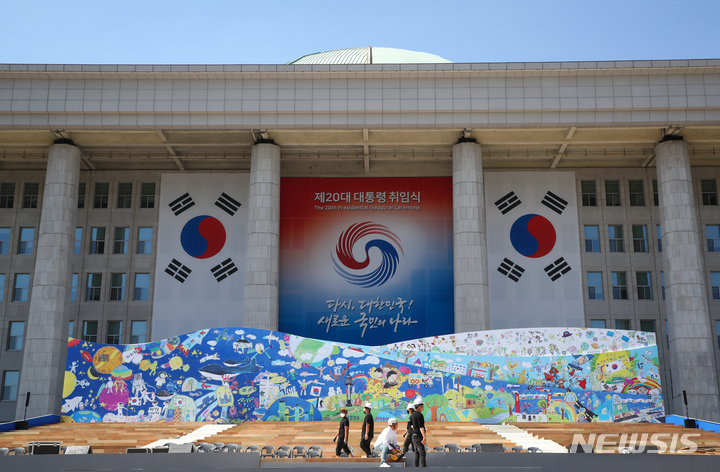 [서울=뉴시스] 김선웅 기자 = 제20대 대통령 취임식을 5일 앞둔 지난 5일 서울 여의도 국회 본관 앞에서 관계자들이 취임식 무대준비를 하고 있다. (공동취재사진) 2022.05.05. photo@newsis.com