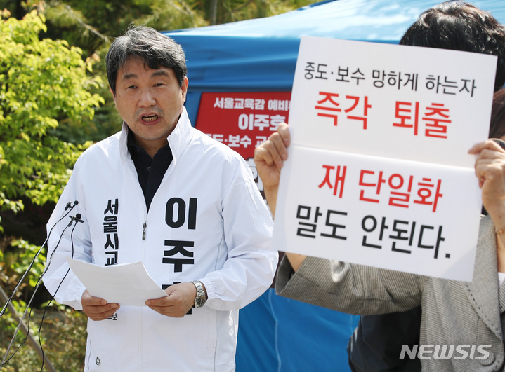 [서울=뉴시스] 김진아 기자 = 이주호 서울시교육감 예비후보가 지난 6일 서울 종로구 서울시교육청 앞에서 중도보수후보 단일화를 촉구하는 단식에 돌입하며 입장문을 발표하자, 이를 반대하는 사람들이 재단일화를 반대하는 손팻말을 들고 있다. 2021.05.07. bluesoda@newsis.com