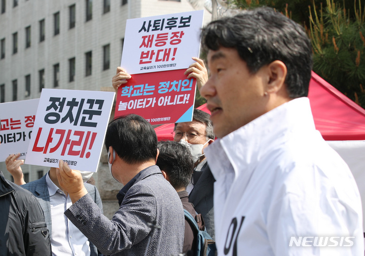 [서울=뉴시스] 김진아 기자 = 이주호 서울시교육감 예비후보가 지난 6일 서울 종로구 서울시교육청 앞에서 중도보수후보 단일화를 촉구하는 단식에 돌입하며 입장문을 발표하자, 이를 반대하는 사람들이 재단일화를 반대하는 손팻말을 들고 있다. 2021.05.07. bluesoda@newsis.com