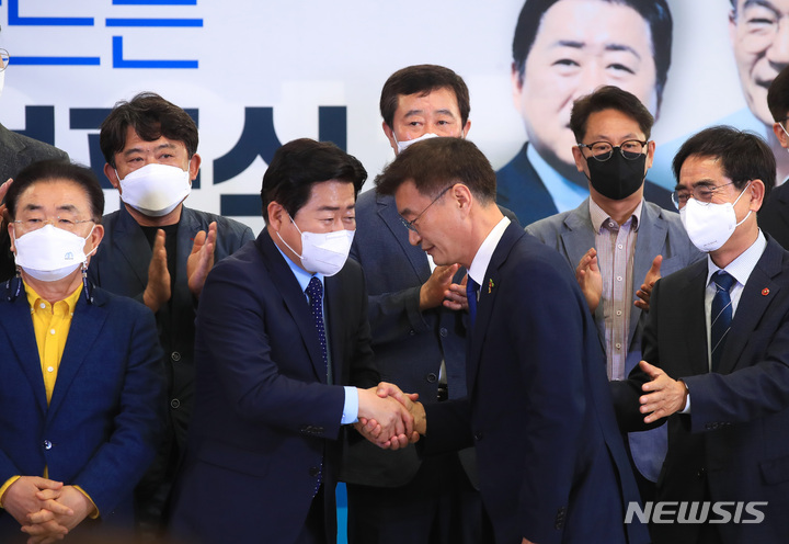 [제주=뉴시스] 우장호 기자 = 더불어민주당 오영훈(왼쪽 두번째) 제주지사 후보와 경선 상대였던 문대림 전 제주국제자유도시개발센터 이사장이 6일 오후 제주시 연동 선거사무소에서 열린 '제주 미래비전 선포식'에서 만나 악수하고 있다. 2022.05.06. woo1223@newsis.com