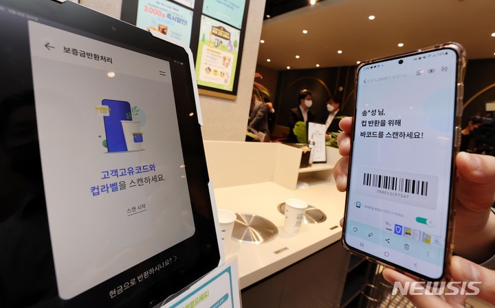 [서울=뉴시스] 권창회 기자 = 지난 5월6일 오후 서울 중구 한 커피전문점에서 환경부 공무원이 1회용 컵 보증금제도를 앞두고 공개 시연을 하고 있다. 2022.05.06. photo@newsis.com