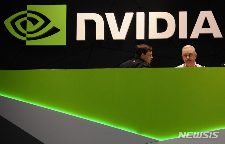 FILE - People gather in the Nvidia booth at the Mobile World Congress mobile phone trade show Thursday, Feb. 27, 2014 in Barcelona, Spain. The Securities and Exchange Commission says it's settled charges against Nvidia, Friday, May 6, 2022, for “inadequate disclosures" related to cryptomining's impact on its gaming business. The technology company will pay a $5.5 million penalty and has agreed to a cease-and-desist order. (AP Photo/Manu Fernandez, File)