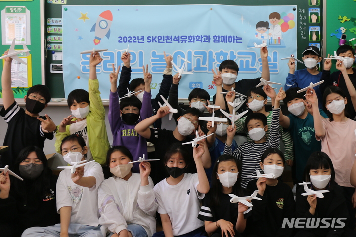 사진설명= 인천 서구 청일초등학교 학생들이 SK인천석유화학과 함께하는 놀이과학교실에서 비행기를 만든 뒤 단체 사진을 촬영하고 있다. (사진= SK인천석유화학 제공) 2022.05.07