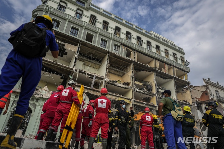 [아바나=AP/뉴시스] 6일(현지시간) 쿠바 수도 아바나에서 적십자 대원들과 구조대가 5성급 호텔 '사라토가' 폭발 현장에 진입할 준비를 하고 있다. 가스 누출로 추정되는 강력한 폭발로 임산부와 어린이 등 최소 27명이 숨지고 수십 명이 다쳤다. 폭발 당시 호텔은 공사 중이어서 투숙객은 없었던 것으로 알려졌다. 2022.05.07.