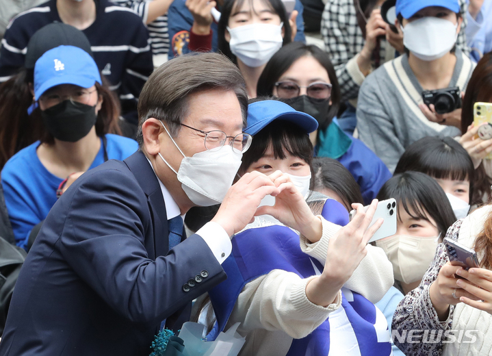 [서울=뉴시스] 전진환 기자 = 이재명 더불어민주당 상임고문이 지난해 5월8일 인천 계양산 야외공연장에서 열린 국회의원 보궐선거(인천 계양을) 출마 기자회견에서 한 지지자와 기념촬영을 하고 있다. (공동취재사진) 2022.05.08. photo@newsis.com