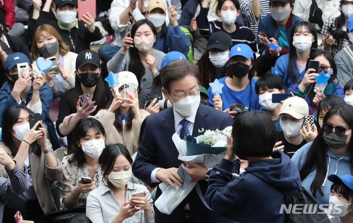 [서울=뉴시스] 전진환 기자 = 이재명 더불어민주당 상임고문이 8일 인천 계양산 야외공연장에서 열린 국회의원 보궐선거(인천 계양을) 출마 기자회견에서 한 지지자로부터 꽃다발을 받고 있다. (공동취재사진) 2022.05.08.  photo@newsis.com