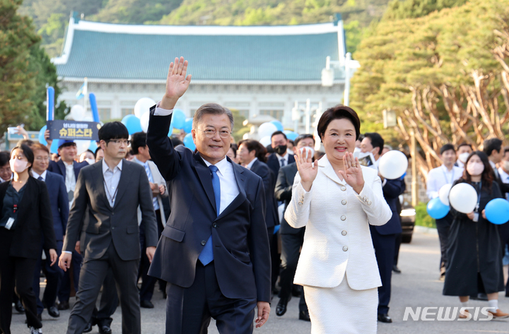 [서울=뉴시스] 전신 기자 = 문재인 전 대통령과 부인 김정숙 여사가 9일 오후 청와대 본관을 걸어 나오며 시민들을 향해 인사하고 있다. 2022.05.09. photo1006@newsis.com