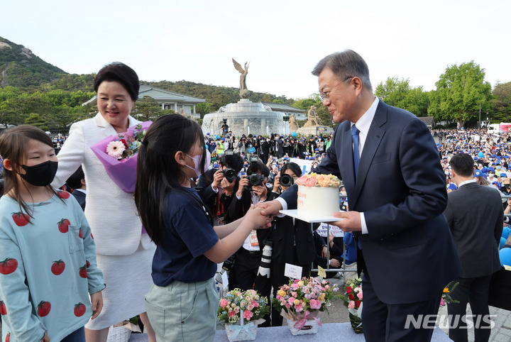 [서울=뉴시스] 홍효식 기자 = 문재인 대통령이 9일 오후 청와대 사랑채 앞 광장에서 어린이에게 케이크를 받고 있다. 2022.05.09. yesphoto@newsis.com