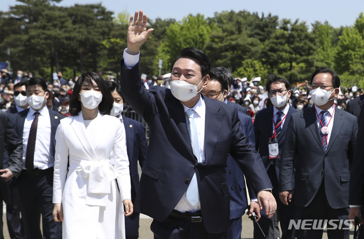 [서울=뉴시스] 전신 기자 = 윤석열 대통령이 10일 서울 여의도 국회 앞마당에서 열린 취임식을 마친 뒤 부인 김건희 여사와 이동하며 시민에게 인사하고 있다. 2022.05.10. photo1006@newsis.com