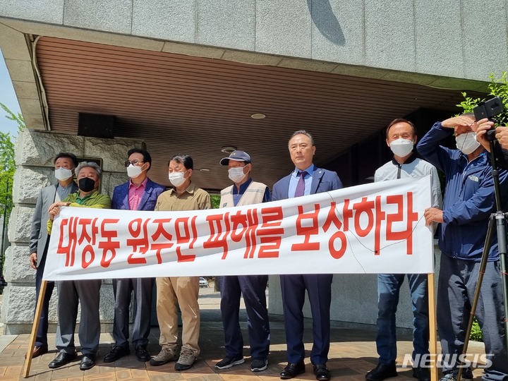 [서울=뉴시스] 대장동 원주민들이 11일 오전 서울 서초구 서울중앙지검 앞에서 이재명 더불어민주당 상임고문 등 대장동 개발 결재권자 15명을 특정경제범죄 가중처벌 등에 관한 법률 위반(배임) 및 도시개발법 위반 혐의로 고발하는 기자회견을 열고 있다. 2022.05.11 photo@newsis.com