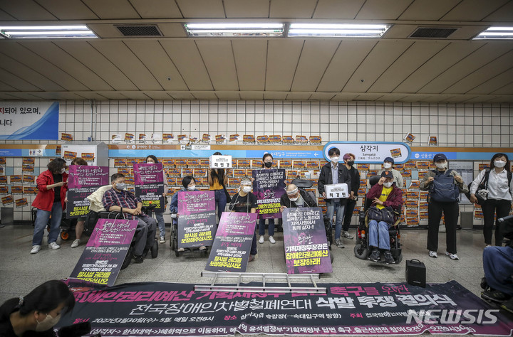 [서울=뉴시스] 정병혁 기자 = 전국장애인자별철폐연대 관계자들이 11일 서울 용산구 삼각지역 승강장에서 열린 장애인 권리 예산 보장 촉구 기자회견에서 구호를 외치고 있다. 2022.05.11. jhope@newsis.com