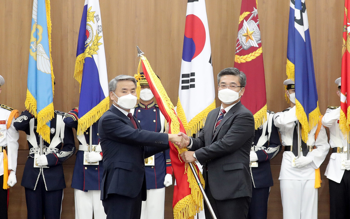 [서울=뉴시스] 이종섭 국방부 장관이 11일 오전 서울 용산구 국방부에서 열린 제47·48대 국방부장관 이·취임식에서 서욱 전 장관으로부터 국방부기를 이양받고 있다. (사진=국방일보 제공) 2022.05.11. photo@newsis.com *재판매 및 DB 금지