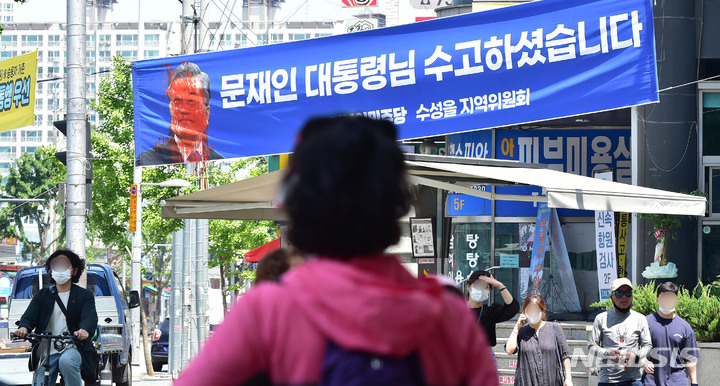 [대구=뉴시스] 이무열 기자 = 11일 오전 대구 수성구 수성시장네거리에 내걸린 문재인 전 대통령 퇴임을 기념하는 현수막이 훼손된 채 발견됐다. 문 전 대통령 얼굴이 빨간 페인트로 훼손됐다. 2022.05.11. lmy@newsis.com