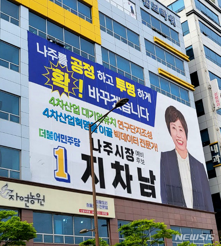 [나주=뉴시스] 6·1 지방선거 더불어민주당 나주시장 경선에 참여했다가 컷오프돼 탈당한 후 국민의힘에 입당한 지차남 예비후보 선거사무소 벽면에 민주당 출마를 알리는 대형 현수막이 걸려 있다. 2022.05.12. lcw@newsis.com