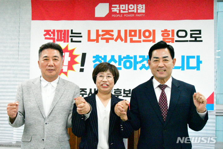 [나주=뉴시스] 이창우 기자= 더불어민주당 나주시장 경선에서 탈락한 지차남 예비후보(가운데)가 국민의힘으로 당적을 옮기고 지난 9일 자신의 선거사무소에서 국민의힘 나주시장 후보 출마를 선언한 가운데 김화진 전남도당위원장(오른쪽)과 김종운 나주지역위원장(왼쪽)과 손을 맞잡고 결의를 다지고 있는 모습.&nbsp; 2022.05.12. lcw@newsis.com