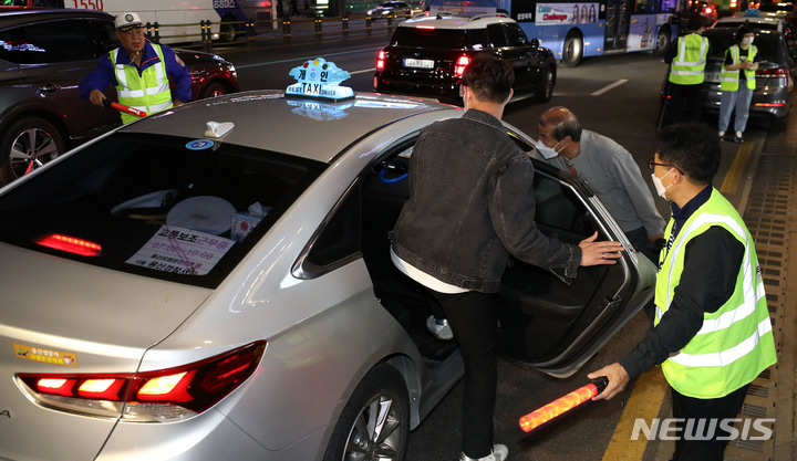 [서울=뉴시스] 백동현 기자 = 지난 5월 서울 서초구 강남역 앞 임시승차대에서 승차 지원단 관계자가 시민들의 택시 탑승을 지원하고 있다. 2022.11.28. livertrent@newsis.com