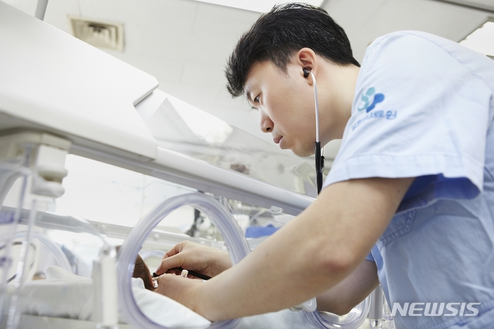 [서울=뉴시스]최용성 경희대병원 신생아 전문 소아청소년과 과장이 진료를 보는 모습. (사진= 경희의료원 제공) 2022.05.13