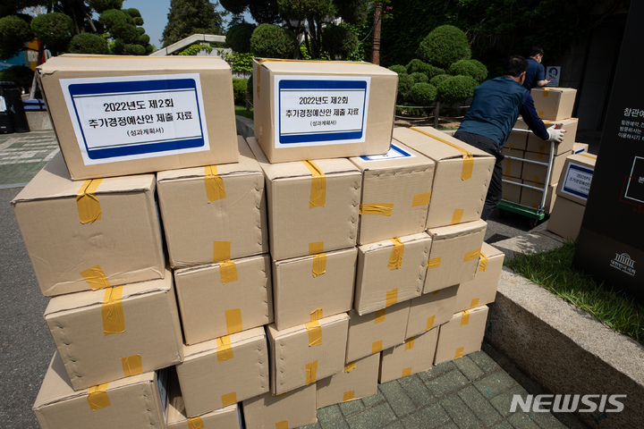 [서울=뉴시스] 최진석 기자 = 13일 서울 여의도 국회 본관2문 앞에서 관계자들이 2022년도 제2회 추가경정예산안 제출 자료(성과계획서)를 옮기고 있다. (공동취재사진) 2022.05.13. photo@newsis.com