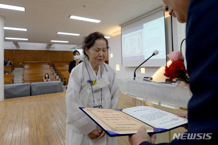 [광주=뉴시스] 김혜인 기자 = 14일 오전 광주 남구 양림동 수피아여자고등학교 강당 지하 1층에서 김덕화 할머니가 모교를 찾아 85년 만에 명예졸업장을 받고 있다. 2022.05.14. hyein0342@newsis.com