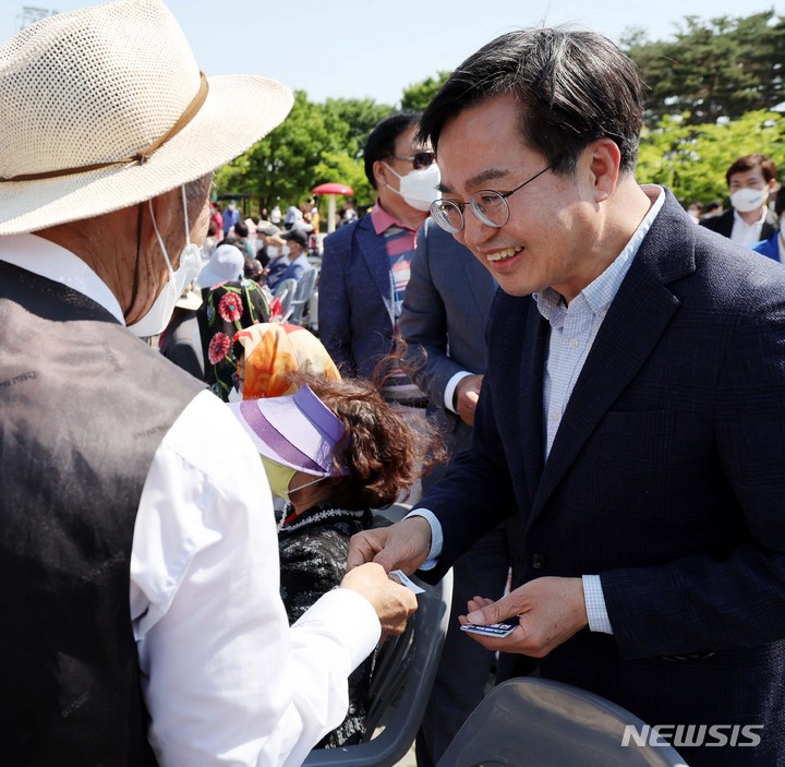 [수원=뉴시스] 국회사진기자단 = 김동연 더불어민주당 경기도지사 후보가 15일 경기도 수원시 제2야외음악당에서 열린 한중수교 30주년 기념 경로대축제에 참석해 참석자들에게 명함을 나눠주고있다. 2022.05.15. photo@newsis.com