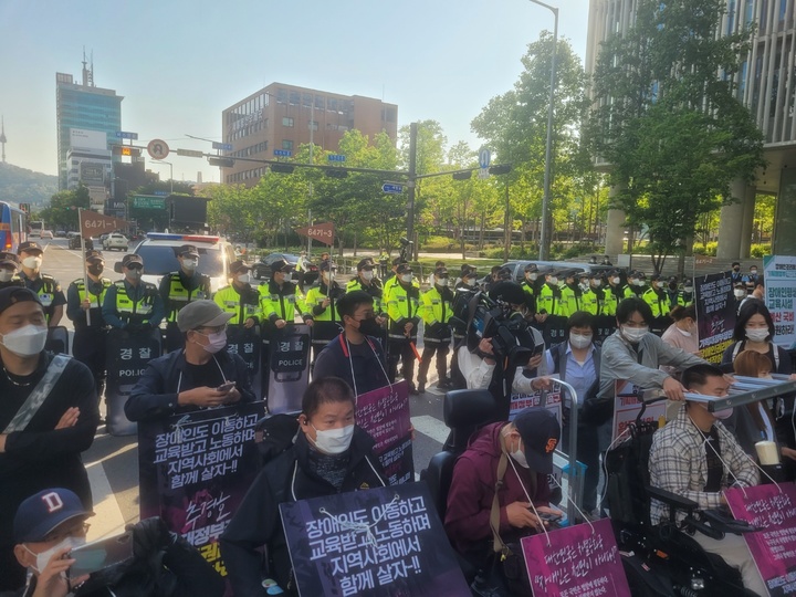 [서울=뉴시스]정유선 기자 = 전장연 관계자 30여명은 16일 오전 7시43분께 서울 용산구 신용산역 인근 8차선 대로를 점거했다. 2022. 5. 16.  *재판매 및 DB 금지