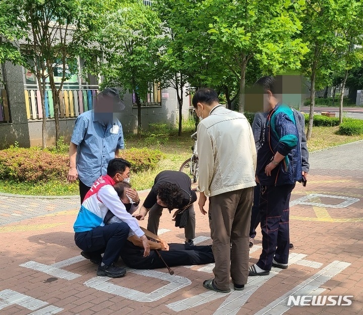 [평택=뉴시스] 경기 평택시 도의원선거에 출마한 윤성근 후보가 길에 쓰러진 노인을 살펴보고 있다. (사진=윤성근 선거사무실 제공)