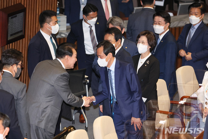 [서울=뉴시스] 전진환 기자 = 윤석열 대통령이 16일 오전 서울 여의도 국회 본회의장에서 추가경정예산안 시정연설을 마치고 정성호 더불어민주당 의원과 인사하고 있다. (공동취재사진) 2022.05.16. photo@newsis.com