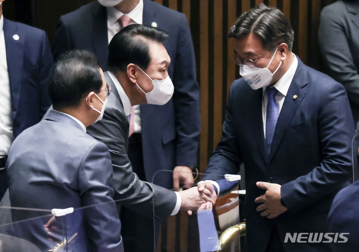 [서울=뉴시스] 최진석 기자 = 코로나19 손실보상을 위한 추가경정예산(추경)안에 대해 시정연설을 위해 국회를 찾은 윤석열 대통령이 16일 본회의장에 입장하며 윤호중 더불어민주당 비대위원장과 인사하고 있다. 왼쪽은 박홍근 원내대표. (공동취재사진) 2022.05.16. photo@newsis.com