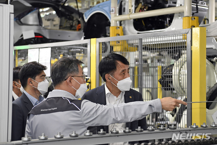 [서울=뉴시스]장영진 산업통상자원부 제1차관(사진 오른쪽 첫 번째)이 18일 기아 오토랜드 화성을 찾아 EV6 생산 라인에 대해 설명을 듣고 있다.(사진=현대자동차그룹 제공) 2022.5.18 photo@newsis.com
