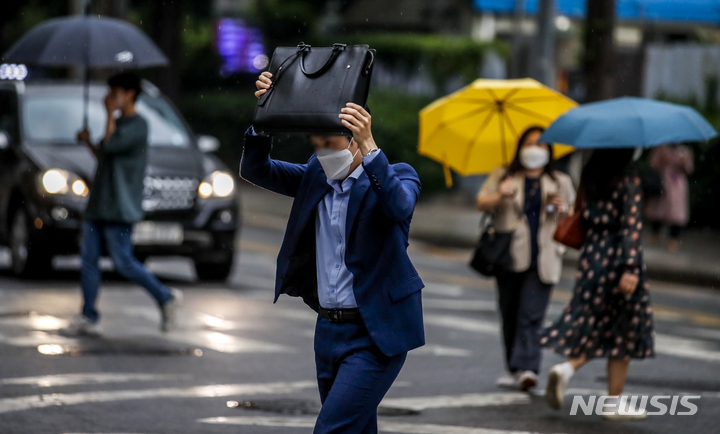 [서울=뉴시스] 정병혁 기자 = 출근길 비가 내린 지난 18일 오전 서울 종로구 정부서울청사 인근에서 우산을 준비하지 못한 시민이 가방으로 머리를 가린 채 이동하고 있다. 2022.05.18. jhope@newsis.com