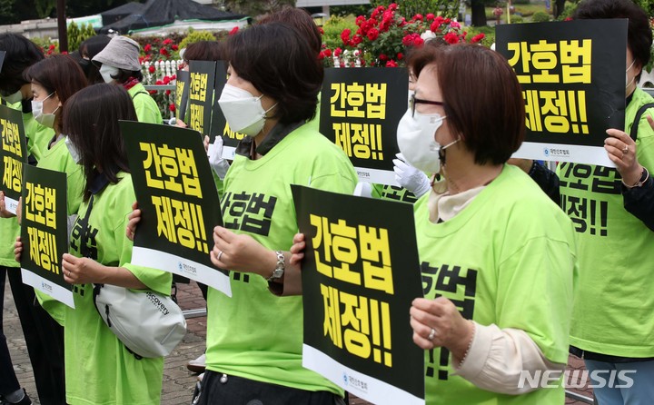 [서울=뉴시스] 고범준 기자 = 대한간호협회 회원들이 18일 오전 서울 여의도 국회 앞에서 간호법의 국회 복지위 전체회의 통과를 환영하는 집회를 하고 있다. 2022.05.18. bjko@newsis.com