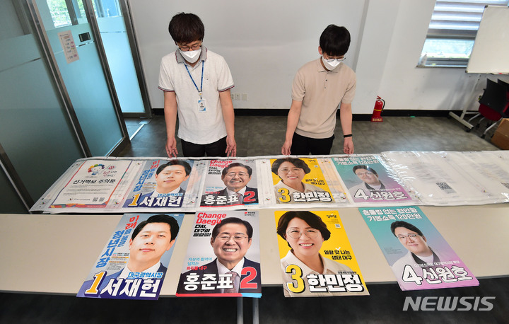 [대구=뉴시스] 이무열 기자 = 제8회 전국동시지방선거 공식 선거운동을 하루 앞둔 18일 오후 대구 서구상중이동행정복지센터 관계자들이 접수된 대구시장 후보자들의 벽보를 살펴보고 있다. 2022.05.18. lmy@newsis.com