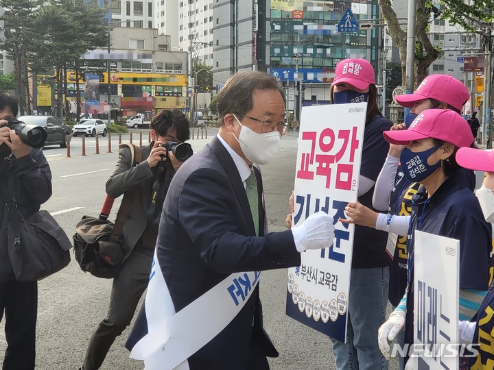 [부산=뉴시스] 이동민 기자 = 김석준 부산시 교육감 후보가 6.1 전국동시지방선거 공식선거 운동이 시작된 19일 오전 부산진구 송상현광장 옆 삼전교차로에서 지지자들과 인사를 나누고 있다. 2022.05.19. eastsky@newsis.com