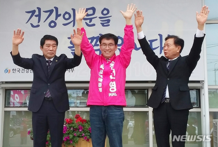 [청주=뉴시스] 김재광 기자 = 윤건영 충북교육감 후보(가운데)가 19일 청주 봉명사거리에서 심의보(오른쪽)·김진균 전 후보와 출정식을 열고 만세를 부르며 선거 승리를 결의하고 있다.2022.05.19.kipoi@newsis.com 