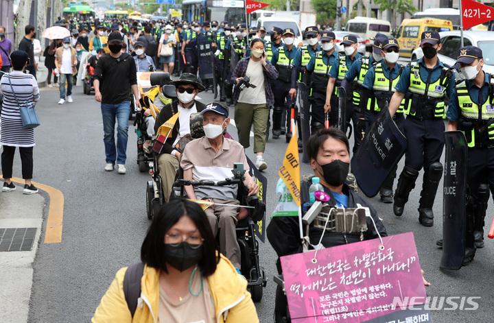 [서울=뉴시스] 이영환 기자 = 박경석 전국장애인차별철폐연대(전장연) 상임공동대표와 회원들이 장애인 권리 예산 추경 반영을 촉구하며 지난달 19일 오후 서울 강남구 도곡동 추경호 부총리 자택 인근에서 강남역 방향으로 행진을 하고 있다. 2022.05.19. 20hwan@newsis.com