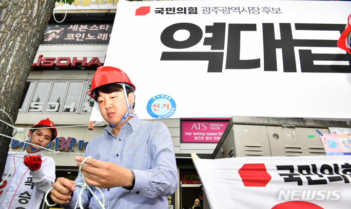 [광주=뉴시스] 변재훈 기자 = 이준석 국민의힘 대표가 20일 오전 광주 북구 용봉동 전남대학교 후문 앞 거리에서 고의 훼손된 당 광주시장·기초의원 후보의 선거 현수막을 철거하고 새 현수막을 직접 걸고 있다. 2022.05.20. wisdom21@newsis.com