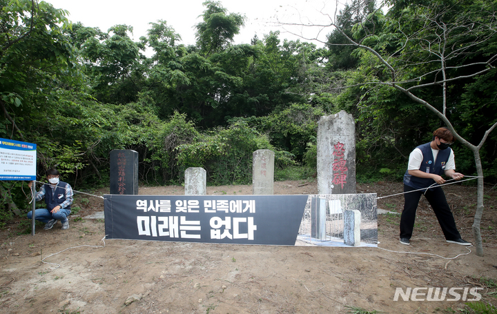 [제주=뉴시스] 제주도보훈청 관계자들이 2022년 5월20일 오후 제주시 한울누리공원 인근 도로변에 있는 박진경 추도비를 감싸고 있던 감옥 형태의 조형물을 철거하는 행정대집행을 진행했다. 이 조형물은 지난 3월 제주4·3기념사업위원회 등 16개 단체가 참여해 추도비를 '역사의 감옥에 가두다'는 의미로 설치했다. 조형물 설치에 참여했던 단체 관계자들이 '역사를 잊은 민족에게 미래는 없다'라고 적힌 현수막을 설치하는 모습. (사진=뉴시스 DB). photo@newsis.com 