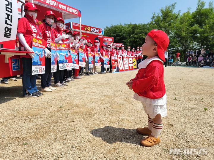 [군위=뉴시스] 김진호 기자 = 경북 군위군 삼국유사면 면민운동장에서 21일 열린 6.1지방선거 국민의힘 후보 선거유세 현장을 한 어린이가 이를 지켜보고 있다. 2022.05.21  kjh9326@newsis.com