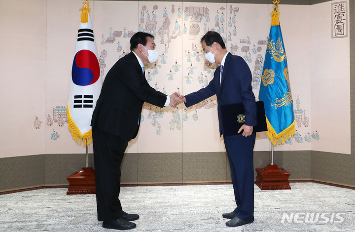 [서울=뉴시스] 홍효식 기자 = 윤석열 대통령이 21일 오전 서울 용산 대통령실 청사 소접견실에서 한덕수 신임 국무총리에게 임명장을 수여한 뒤 악수하고 있다. 2022.05.21. yesphoto@newsis.com