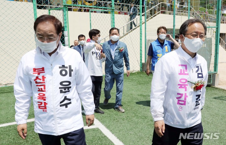 [부산=뉴시스] 하경민 기자 = 제8회 전국동시지방선거를 열흘 앞둔 22일 부산 부산진구 개성고등학교에서 열린 총동창회 체육대회에 참석한 하윤수(왼쪽) 부산교육감 후보와 김석준 부산교육감 후보가 시축을 하기 위해 이동하고 있다. 2022.05.22. yulnetphoto@newsis.com