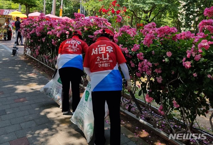 [대구=뉴시스] 정창오 기자=기초의원 대구 달서구 가선거구(용산 1·2동, 죽전동, 장기동)에 출마한 국민의힘 서민우(2-나) 후보 선거운동원들이 유세전 대신 공원 주변을 청소하고 있다. 2022.05.23 jco@newsis.com *재판매 및 DB 금지