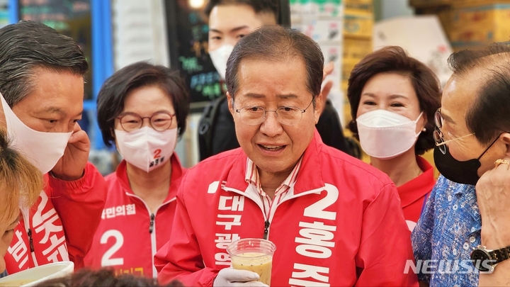 [대구=뉴시스] 이지연 기자 = 국민의힘 홍준표 대구시장 후보가 23일 오후 대구 남구 관문시장을 찾은 가운데 냉 콩국물을 마시며 상인들과 이야기 하고 있다. 2022.05.23. ljy@newsis.com