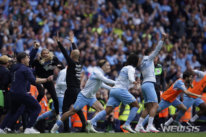 [맨체스터=AP/뉴시스] 펩 과르디올라 감독을 비롯한 맨체스터 시티 선수단이 23일(한국시간) 영국 맨체스터 이티하드 스타디움에서 열린 아스톤 빌라와 2021~22 EPL 최종 38라운드 홈경기에서 3-2로 이기고 우승을 확정한 뒤 그라운드로 뛰어나가며 기뻐하고 있다. 2022.05.23.