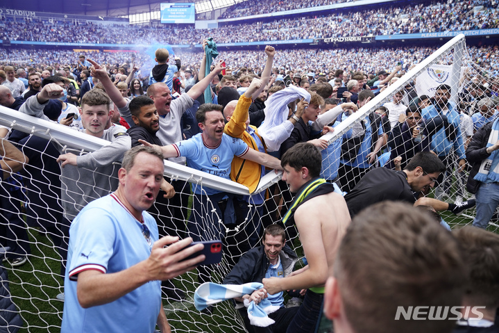 [맨체스터=AP/뉴시스] 맨체스터 시티 팬들이 23일(한국시간) 영국 맨체스터 이티하드 스타디움에서 열린 아스톤 빌라와 2021~22 EPL 최종 38라운드 홈경기에서 3-2로 이기고 우승이 확정된 뒤 그라운드에 몰려들어 기쁨을 나누고 있다. 2022.05.23.