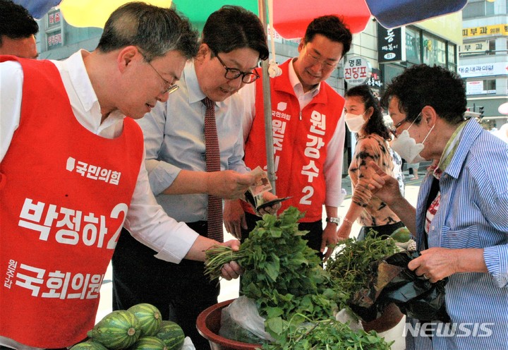 [원주=뉴시스] 이덕화 기자 = 24일 박정하 원주갑 국회의원 후보와 원강수 원주시장 후보 유세를 지원하기 위해 원주시를 찾은 권성동 국민의힘 원내대표가 중앙시장 상인들에게 지지를 호소하며 제철 봄나물을 사고 있다. 2022.05.24. wonder8768@newsis.com