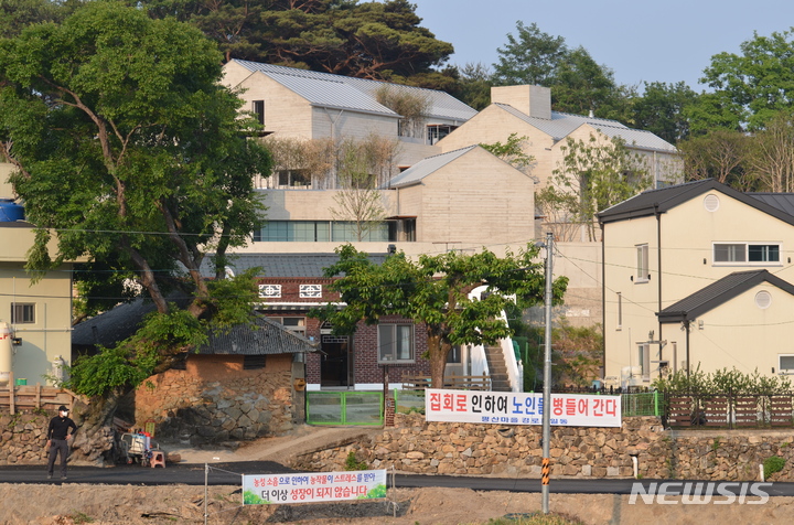 [양산=뉴시스] 안지율 기자 = 24일 오후 경남 양산시 하북면 평산마을 문재인 전 대통령 사저 앞 도로에 보수단체가 진행하는 집회 소음으로 인한 주민 생활 불편을 호소하는 현수막이 걸려 있다. 2022.5.24. alk9935@newsis.com