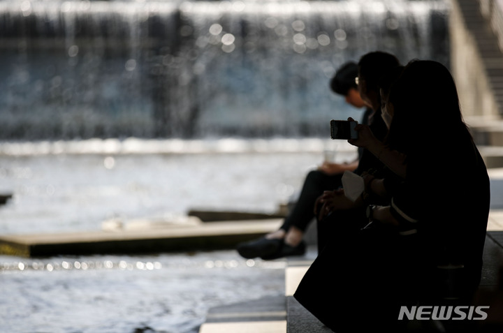 [서울=뉴시스] 정병혁 기자 = 서울 낮 최고 기온이 29도 까지 오르는 더운 날씨가 이어진 지난 24일 오후 서울 중구 청계천을 찾은 시민들이 햇빛을 피해 휴식을 취하고 있다. 2022.05.24. jhope@newsis.com